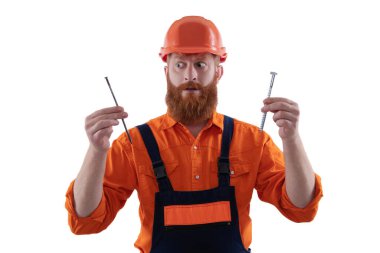 Sakallı marangoz çivi tutar. Marangoz, beyaz çiviyle tamir ediyor. Tamirci. Adam çekiç çivisi tutuyor. Marangozluk tamir ve çekiç. Üniformalı tamircinin çivisi var. Marangozluk esasları..