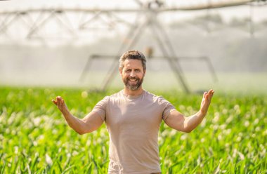 Damlatma sulama sistemi. Ekin sulama. Tarım ve tarım. Sulama sisteminde tarımı sulayan bir adam. Çiftçi adam sonuç sunuyor. Su fıskiyesi sulama tarlası.