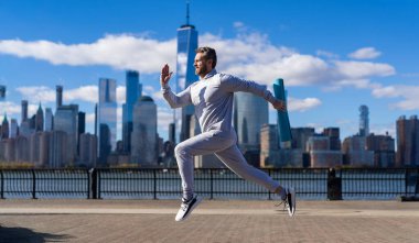Koşucu uzun spor koşusunda. Koşucu dışarıda spor antrenmanında koşuyor. New York 'ta sabah sporu koşucusu. Sporcu adam koşuyor. Manhattan 'da koşan adam. Kros koşusu.