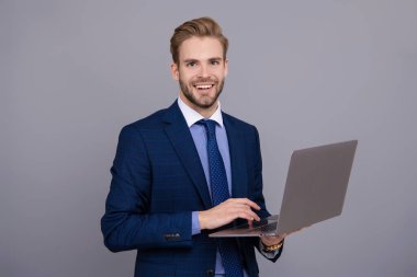 Grey 'de izole edilmiş dizüstü bilgisayar kullanan bir iş adamı. Çevrimiçi çalışan serbest çalışan biri. Adamın online blogu var. Ofisinde dizüstü bilgisayarla takım elbiseli bir iş adamı. Uzaktan kumandalı çalışıyor. İş blogu başarısı. E- posta cevaplanıyor.