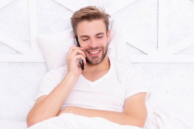 Telefon var. Yatakta akıllı telefonu olan bir adam. Akıllı telefon iletişimi. Milenyum adamı yatak odasında akıllı telefon kullanır. Hastalık izni iste. Yatakta telefonla konuşan genç bir adam. Telefona bağımlılık.