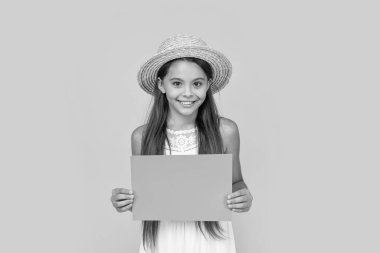 Sarı arka planda turuncu kağıtta fotokopi alanı olan neşeli bir çocuk..