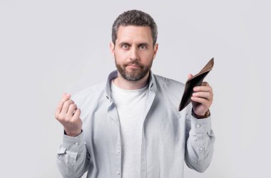 Cüzdanı olmayan parasız bir adam stüdyo arka planında, krizde. Stüdyoda cüzdanı olmayan bir adam. Elinde cüzdanı olan parasız bir adam. Cüzdanlı parasız bir adamın fotoğrafı..
