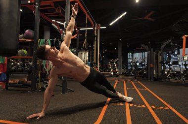 Sporcu spor salonunda yan tahta egzersizi yapar. Beden eğitiminde yan tahta egzersizi. Spor ve spor. Spor salonunda atletizm egzersizi..