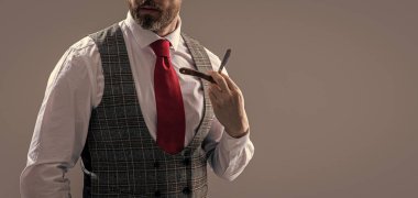 Berber stüdyosunda berberlik yapan adam, fotokopi odası. Sakallı adam berber. Traşsız adam berber bıçağı gri arka planda izole edilmiş. Adam berber bıçağıyla tıraş oluyor..