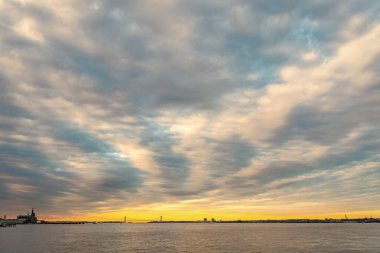 Köprüsü olan modern şehrin mimarisi. Şehir manzaralı ya da ufuk çizgisi olan deniz manzarası. Skyline mimarisi. Şehir manzarasında gün doğumu görünümü.