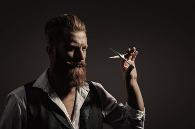 Saç keserken makas kullanan yakışıklı berber. Modern berber saç kesimi. Siyah sakallı hippi berber. Berberdeki kuaförden sakal kesimi. Boşluğu kopyala.