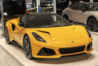 New York City, ABD - 27 Mart 2024: Lotus Emira spor araba sarı renk New York Uluslararası Otomobil Fuarı, köşe manzara.