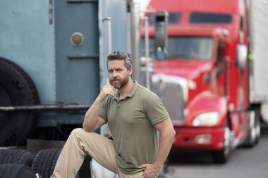 Kamyonun önünde yakışıklı bir şoför. Kamyon sahibi. Kamyon şoförü. Kamyon kamyonunun yanında bir erkek kamyon şoförü. Nakliye araçları. Yarı kamyon aracı. İspanyol kamyoncu adam. İşçi Bayramı.