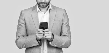 Telefon kullanan bir iş adamı. Erkek telefon konuşması. Telefonu olan orta yaşlı bir İspanyol iş adamı. İş iletişimi. Gri yolda izole bir şekilde telefonda sohbet eden sıradan bir iş adamı. İnternet sörfü.