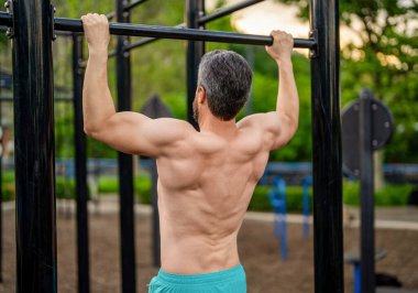 Sporcu adam barfiks egzersizi yapar. Kas kasları ve trisepsler. Güçlü bir atlet. Adam spor salonuna yanaştı. Güçlü sırt kası olan kaslı bir sporcu. Spor barfiks egzersizi. Spor eğitimi. Vücuda uygun.