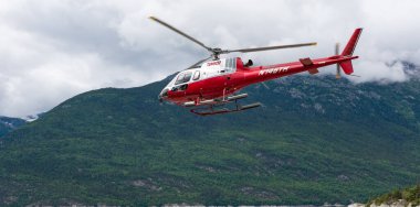 Skagway, Alaska, ABD - 23 Temmuz 2019: Temsco Helicopters Inc. Temsco kırmızı helikopter Skagway, Alaska. Temsco 'nun turistik helikopteri. Skagway helikopter turu. Uçuş turu..