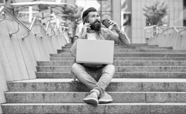 Cep telefonuyla konuşan sakallı adam kahve içiyor. Dışarıdaki merdivenlerde dinlenen bir adam mobil arama yapıyor. Cep telefonundan arıyorlar. Mobil iletişim. Telefon görüşmesi.