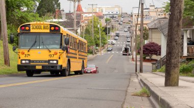 Astoria, Oregon, ABD - 21 Mayıs 2019: Sokaktaki okul otobüsü. Yoldaki sarı okul otobüsü. Okul otobüsü. Sarı okul otobüsü olan şehir sokağı..