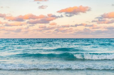 Yaz tatilinde gün batımı deniz manzarası. Deniz kıyısında gün doğumu. Denizde dramatik gündoğumu ufku. Günbatımı deniz manzarasında romantik bir yaz tatili. Okyanusta gün batımı. Deniz dalgaları.