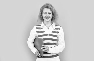 Stüdyoda serbest çalışan mutlu bir kadın. Dizüstü bilgisayarı olan serbest çalışan bir kadın. Bilgisayarı tutan serbest çalışan bir kadın. Gri arka planda serbest çalışan kadın..