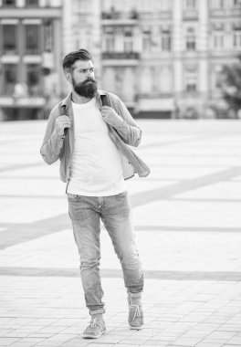 Dışarıda yürüyen sakallı bir turist. Sakallı, uzun boylu, beyaz bir turist. Sıradan bir turist..