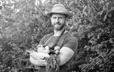 man in straw hat hold fresh ripe vegetables.