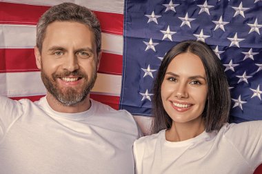 Amerikan bayrağıyla çift portresi. Vatansever çift Independence 'ı onurlandırıyor. Bağımsızlık Günü 'nde Amerikalı bir çift. Amerikan çifti Bağımsızlık Günü ruhunu bayrakla kucaklıyor. Bağımsızlık Günü tatili.