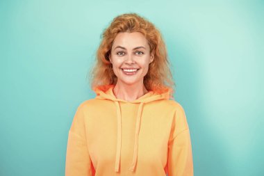 Sıradan kapüşonlu, şık, beyaz bir kadın. Modayla ilgilenen kız modaya uygun ve parlak görünüyor. Mavi üzerine kapüşonlu giyen kadın. Moda modeli. Şık kapüşonlu kızıl saçlı kız. Sportif şık.