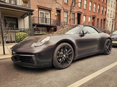 New York City, ABD - 10 Şubat 2024: Porsche 911 Carrera 4 'ler siyah araba, yan köşe manzaralı.