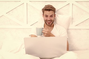 Kahve ve dizüstü bilgisayarı olan serbest çalışan bir adam evinde video görüşmesi yapıyor..