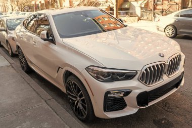 New York City, ABD - 24 Mart 2024 BMW X6 xDrive40i SUV araba dışarıda park edilmiş, köşe manzara.