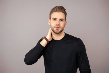 Milenyum karizmatik modeli. Erkeklerin güzelliği. Kendine güveni olan adam. Gündelik kazak giyen genç yakışıklı bir adam. Tıraşsız adam Griler 'de izole edilmiş. Şık saç kesimi olan bir adamın portresi. Manyetik Varlık.