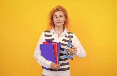 Okul biyoloji öğretmeni kadının elinde mikroskop var. Kadın biyoloji öğretmeni. Okula dönelim. Mikroskobu olan öğretmen sarıda izole edilmiş. Kadınlar için biyoloji bilimi. Mikroskop araştırması.