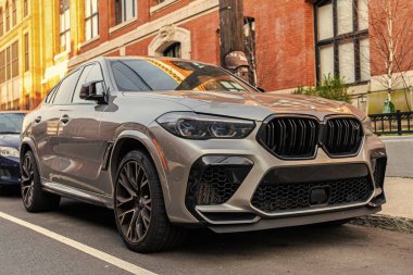 New York, ABD - 15 Mart 2024: BMW X6 lüks otomobil cadde, köşe manzara park.