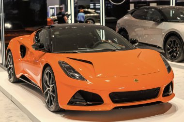 New York, ABD - 27 Mart 2024: Lotus Emira spor araba turuncu renkli New York Uluslararası Otomobil Fuarı, köşe manzaralı.