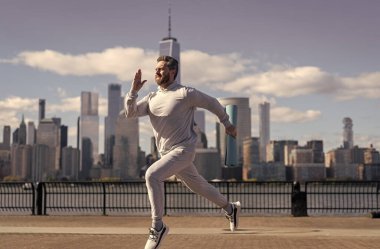 Manhattan 'da koşan adam. Koşucu uzun spor koşusunda. Koşucu dışarıda spor antrenmanında koşuyor. New York 'ta sabah sporu koşucusu. Sporcu adam koşuyor. İz çalışıyor.