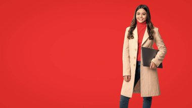 Genç kız dizüstü bilgisayarı tutuyor. Online eğitim. Okula dönelim. Bilgi ve çevrimiçi eğitim. Dizüstü bilgisayarda video dersi. Uzay afişini kopyala. Dizüstü bilgisayarı olan genç kız kırmızıda izole edilmiş..