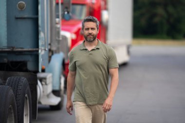 Kamyonun önünde yakışıklı bir şoför. Kamyon sahibi. Kamyon şoförü. Kamyon kamyonunun yanında bir erkek kamyon şoförü. Nakliye araçları. Yarı kamyon aracı. İspanyol kamyoncu adam. Dağıtım.