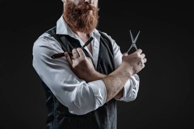 Saç keserken makas ve retro bıçak kullanan yakışıklı berber. Modern berber saç kesimi. Siyah sakallı hippi berber. Berberdeki kuaförden sakal kesimi. Taze saç kesimi.