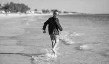 Denizde dizüstü bilgisayarla koşan takım elbiseli bir iş adamı. Başarılı bir iş adamı yazın tadını çıkarır. Yaz tatilindeki iş adamı. İnsanoğlunun iş başarısı. Yaz rüyaları.