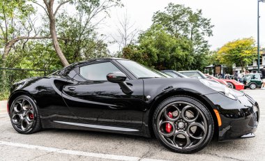Chicago, Illinois - 29 Eylül 2024: 2015 Alfa Romeo 4C Coupe siyah rengi. P2015 Alfa Romeo 4C Coupe sokağa park etmiş. Köşeden bak. 2015 Alfa Romeo 4C Coupe Chicago 'da