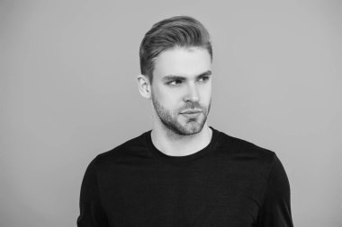 Kendine güvenen adam portresi. Erkeklerin cilt bakımı. Erkek derisi. Adamın şık bir saç kesimi var. Moda saç stili olan bir adam. Sıradan erkek tarzı. Kafkasyalı genç adam gri yolda izole edilmiş..