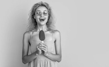 Arka planda dondurmalı ve fotokopi alanı olan bir kadın. Yazın dondurmalı bir kadının fotoğrafı. Dondurmalı kadın sarıda izole edilmiş. Stüdyoda dondurmalı kadın..