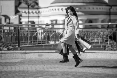 Sonbahar şehrinde gezen kız. En iyi satış teklifi. Sonbaharda alışveriş yapan genç bir moda kızı. Sonbahar alışverişi. Genç kız sonbahar kıyafetiyle alışverişe gider. Alışveriş ve indirim. Boşluğu kopyala.