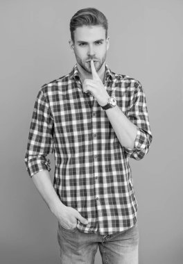 Adam sessiz sedasız sır saklıyor. Normal erkek stili. Erkeklerin güzellik anlayışı. Kafkasyalı milenyum adamı. Kareli tişörtlü adamın gri üzerinde gizli bir bölmesi var. Saç stili olan yakışıklı bir genç. Sessiz ol..