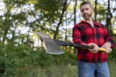 Vahşilik ve erkeklik. Baltalı oduncu seçici odaklı. Acımasız oduncu. Ormandaki oduncu. Baltalı bir adam. Balta adamın elinde odun kesiyor. Odun kesiyorum. Keskin bıçak.
