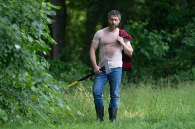 Vahşilik ve erkeklik. Baltalı oduncu terliyor. Oduncu baltası. İspanyol adam ormanda baltayla çalışıyor. Ormanda baltayla oduncu. Keresteci gömlekli ve baltası ağır. Acımasız adam..