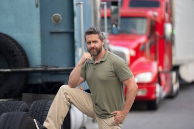 Kamyonun önünde yakışıklı bir şoför. Kamyon sahibi. Kamyon şoförü. Kamyon kamyonunun yanında bir erkek kamyon şoförü. Nakliye araçları. Yarı kamyon aracı. İspanyol kamyoncu adam. İhracat servisi.