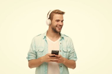 Beyazlar içinde izole edilmiş akıllı telefon uygulaması kullanan adam. Telefonla müzik dinlemek. Müzik yaşam tarzı. Ses çalma listesi. Kulaklıklı adam. Kulaklıklı adam telefonda mp3 çalma listesini seçiyor. Çevrimiçi günlük.