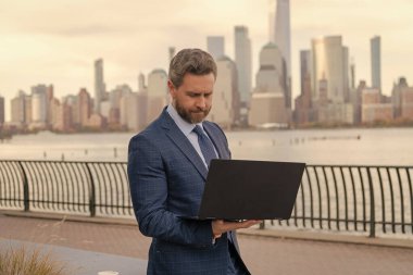 İş adamı dışarıda bilgisayar ya da dizüstü bilgisayarda çalışmakla meşgul. Adam internet tarayıcısından iş e-postası ve sörf yolluyor. New York 'ta serbest çalışan bir iş adamı. İnternette çalışan bir iş adamı. Anahtar ortaklıkları geliştir.