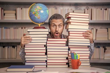 Ders kitabı olan inek bir adam. Okul edebiyat eğitimi. Sınıftaki inek adam. Okul kütüphanesinde kitap kurdu. Eğitim ve bilgi. Sınıftaki erkek öğretmen. Okul eğitimi. Edebi analiz.