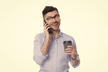 İş iletişimi. Adam iş konuşuyor. Telefon var. İş adamı iletişim için telefonu kullanıyor. Kahveli bir iş adamı beyazın üstüne izole edilmiş. Kahve molası. Zamansal geri bildirim.