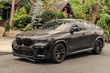 New York City, ABD - 26 Ağustos 2023: BMW X6 SUV araç geçişi park edilmiş, köşe manzaralı.