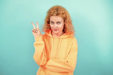 Moda modeli. Şık kapüşonlu kızıl saçlı kız. Sıradan kapüşonlu, şık, beyaz bir kadın. Modayla ilgilenen kız modaya uygun ve parlak görünüyor. Mavi üzerine kapüşonlu giyen kadın. Barış.